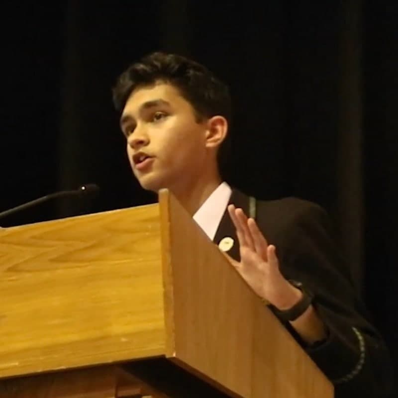 Namra Shah speaking at a lectern